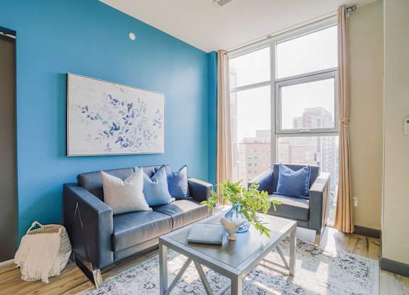 a living room with blue walls and a large window
