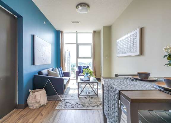 a living room with a blue accent wall and a window