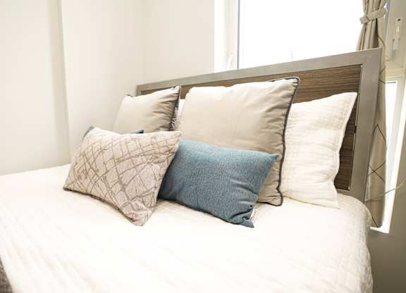 a bedroom with a bed with pillows on it