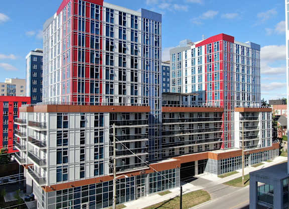 A modern building with red and blue accents stands tall against a clear sky.