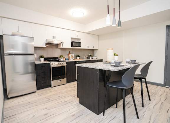 A modern kitchen with a table and chairs.