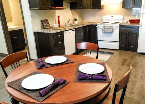 A kitchen with a table set for two.