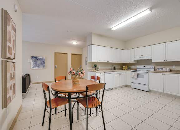 A kitchen with a table and chairs in the middle of the room.