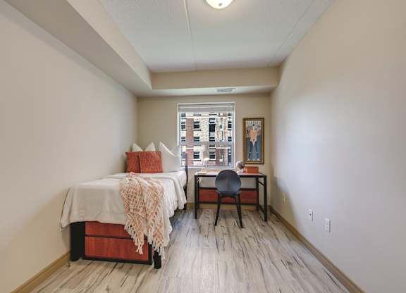 A bedroom with a bed, desk, and chair.