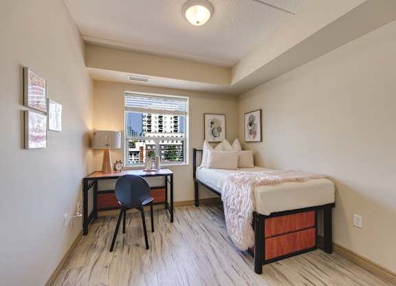 A bedroom with a bed, desk, and chair.