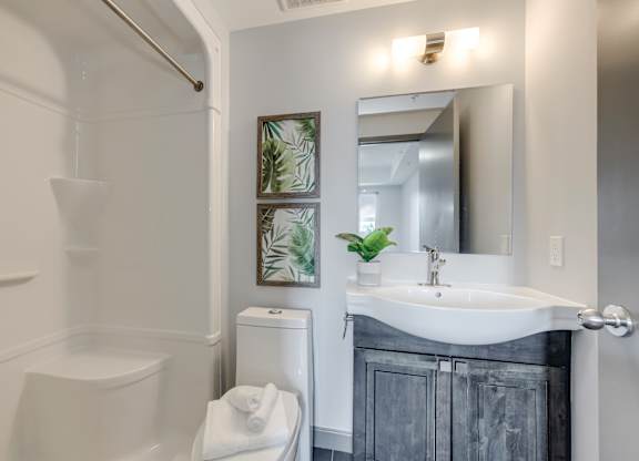A white toilet sits next to a white sink in a bathroom.
