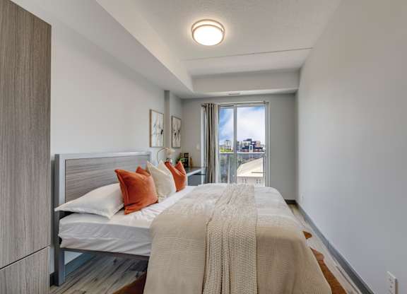 A bedroom with a bed, pillows, and a blanket.