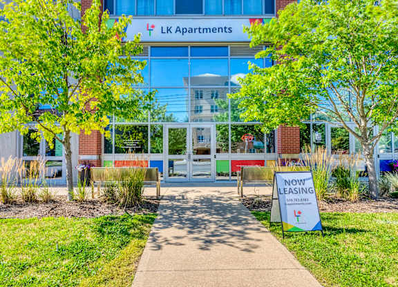 A building with a sign that says "LK Apartments" in front of it.