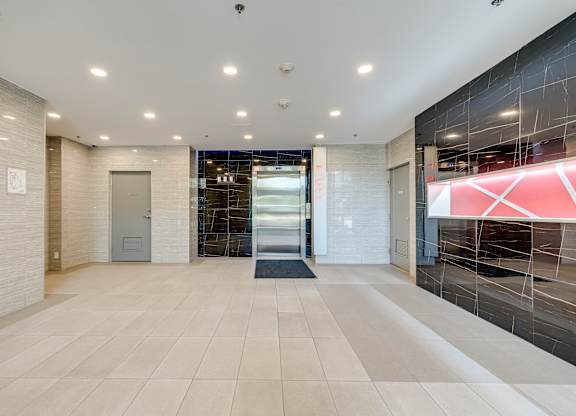 A hallway with a tiled floor and a glass door.