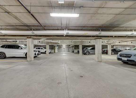 A parking garage with multiple cars parked.