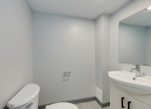 A white toilet sits next to a sink in a small bathroom.