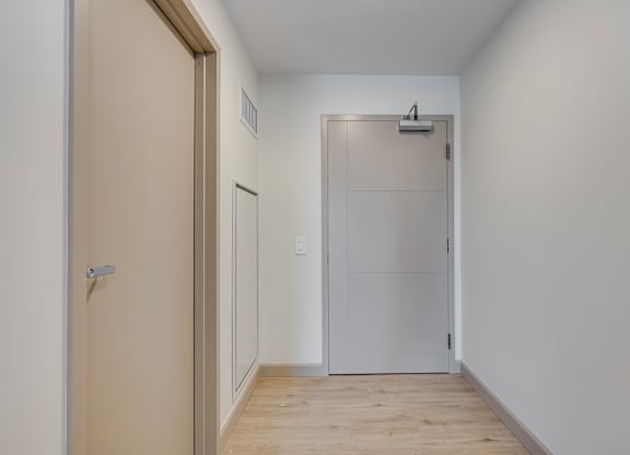 A white door is in the middle of a hallway.