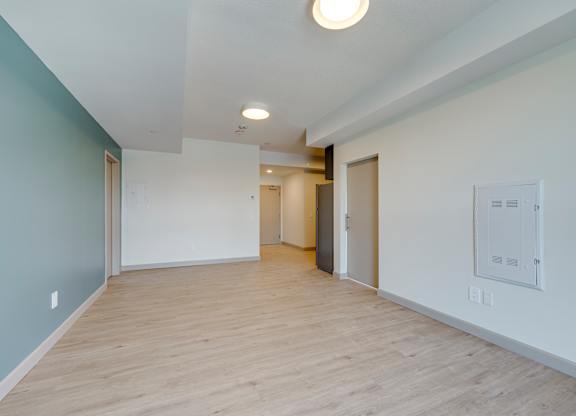 A long hallway with a white door on the right and a light on the ceiling.
