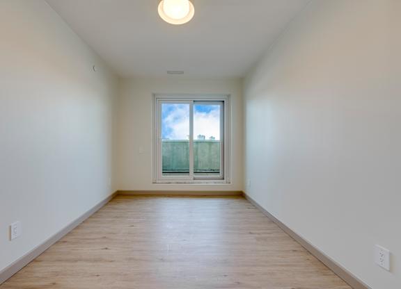 A room with a window and wooden floor.