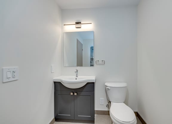A white toilet sits next to a sink in a small bathroom.