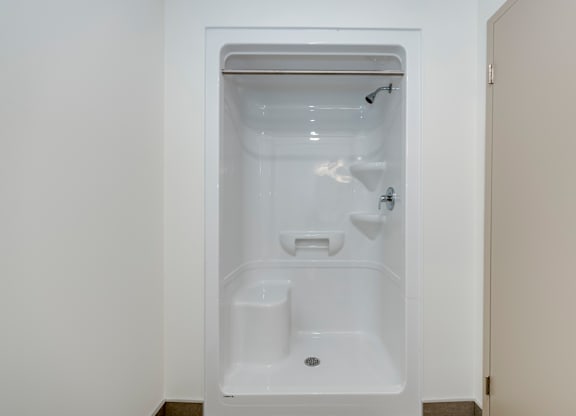 A white bathroom with a walk in shower.