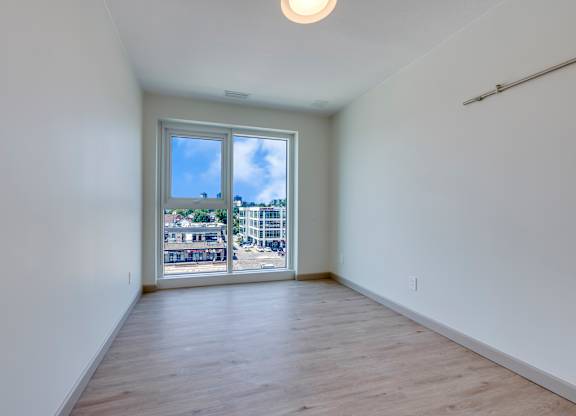 A room with a sliding glass door leading to a balcony.