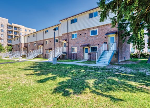 A sunny day at a grassy courtyard with apartment buildings in the background.