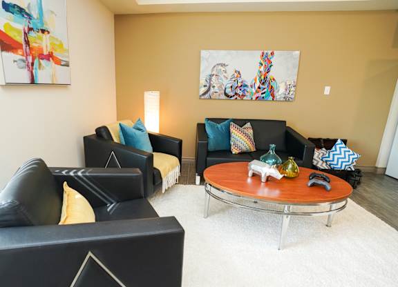 A living room with a black couch and a coffee table.