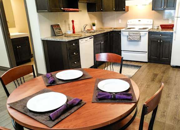 A kitchen with a table set for two.