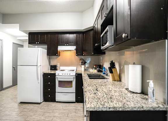 a kitchen with white appliances and a granite counter top