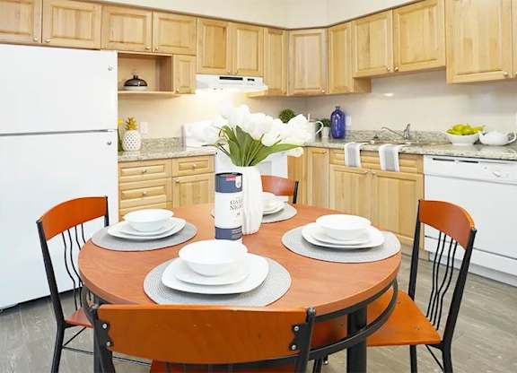 A kitchen with a table set for two.