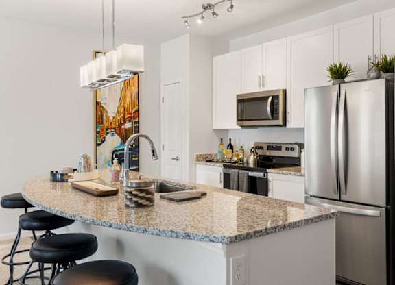 A kitchen with granite countertops and stainless steel appliances.