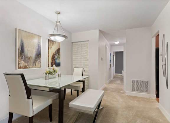 A dining room with a glass table and chairs.