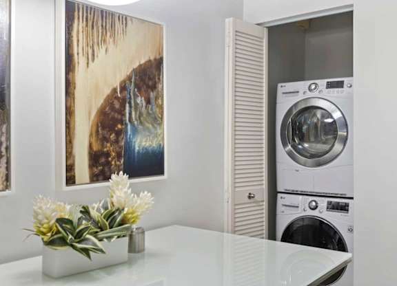 A modern laundry room with a washer and dryer stacked on top of each other.