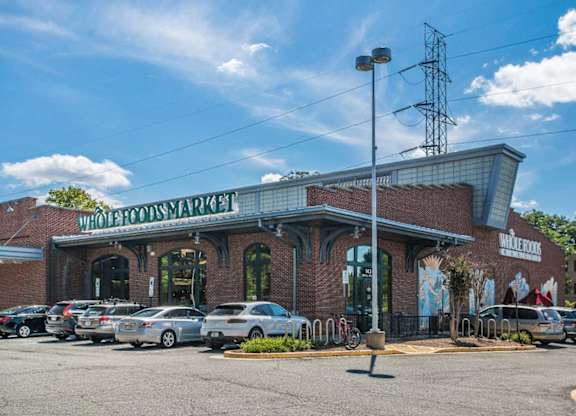 A Whole Foods Market store with cars parked in front.