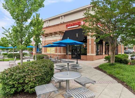 Cold Stone Creamery with a patio outside of a restaurant with tables and umbrellas