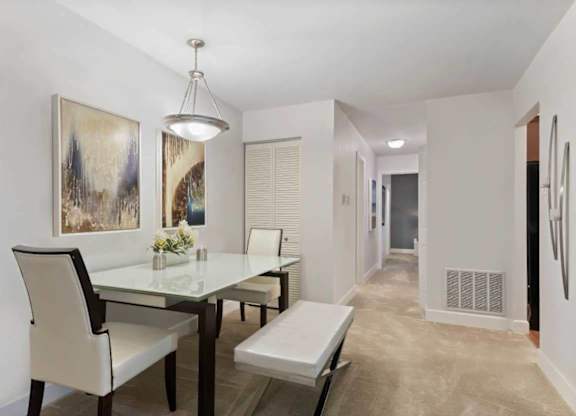 A dining room with a glass table and chairs.