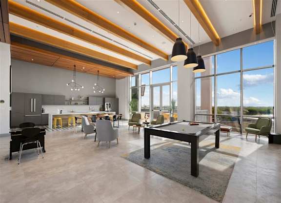 a large living room with a pool table  and a kitchen