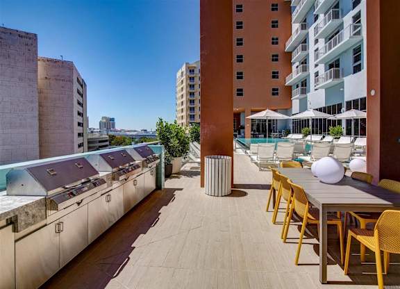 a rooftop terrace with tables and chairs and a pool