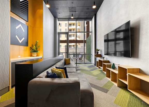 a lobby with couches and a tv in a building