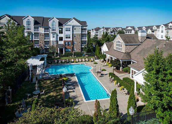 an aerial view of a swimming pool with apartments in the background
