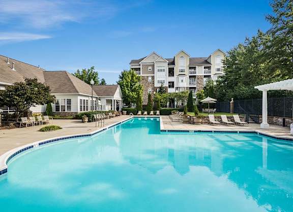 a large swimming pool with apartment buildings in the background