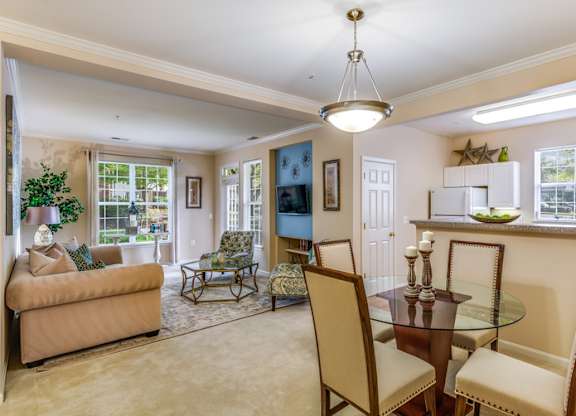 a living room and dining room with a table and chairs