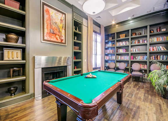 a game room with a pool table and a library