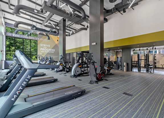 a gym with cardio machines and weights in the lobby of a building