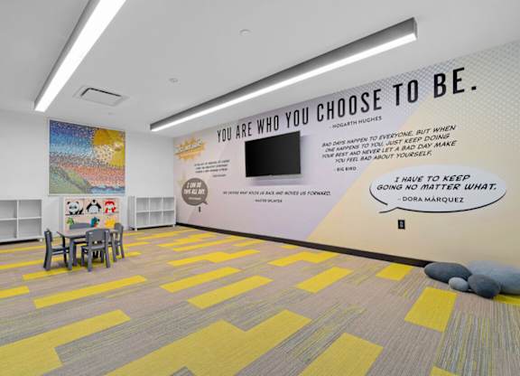 a large room with tables and chairs and a wall saying you are who you choose