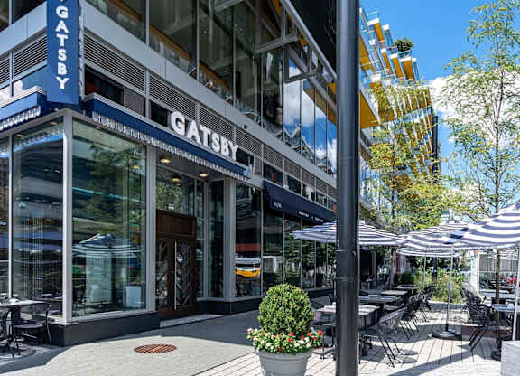 a restaurant with tables and umbrellas outside of a building