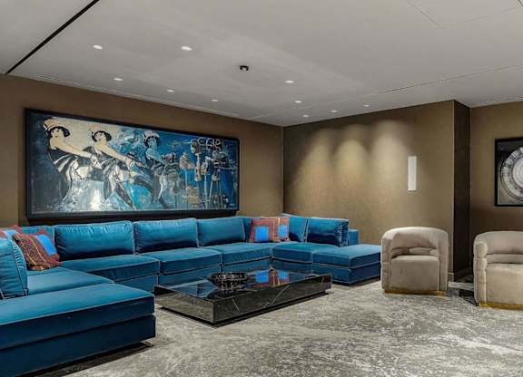 a curved seating area with blue chairs and a large mural on the wall