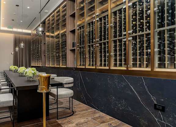 a long bar in front of a wine cellar in a hotel room