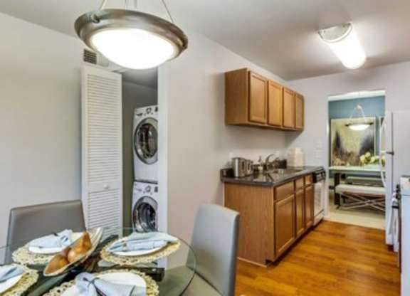 a dining room table and a kitchen with a washing machine