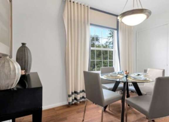a dining room with a table and chairs and a window