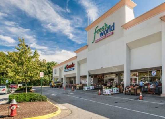 the facade of a grocery store with a parking lot