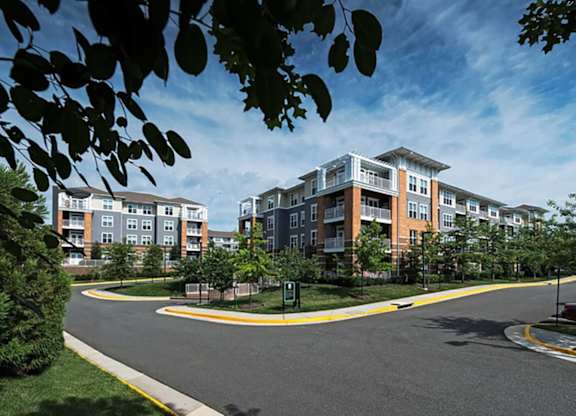 a street view of an apartment building with a road in front of it