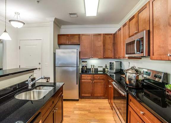a kitchen with wooden cabinets and a stainless steel refrigerator