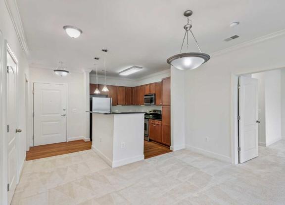an empty kitchen with a counter top and a refrigerator